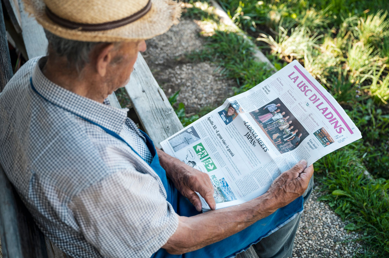 Ein Mann liest in der ladinischsprachigen Zeitung La Usc di Ladins.