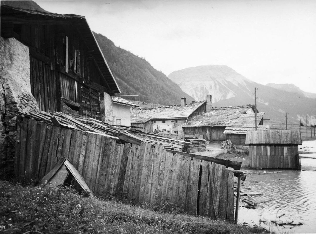 Hütten und Häuser im alten Dorf Graun vor der Überflutung durch den Stausee.