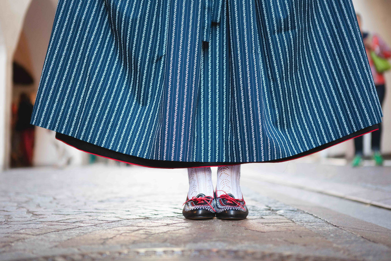 	Meraner Tracht für Frauen: Detailaufnahme eines bodenlangen, blau-gestreiften Trachtenrocks