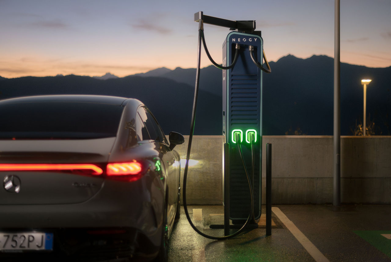 Eine E-Ladesäule von Alpitronic, daneben ein luxuriöses Auto.