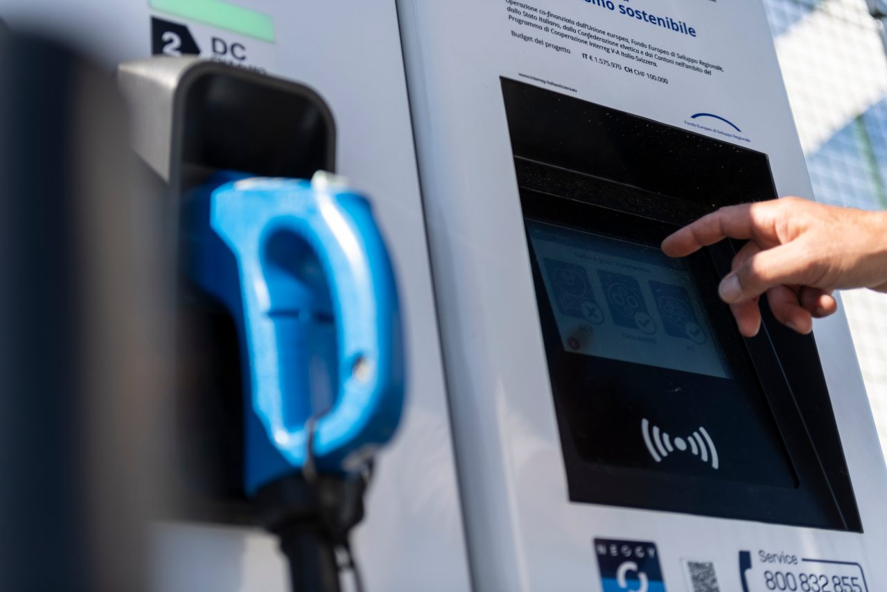 Ein Mann lädt sein Auto an einer Elektro-Ladestation auf.