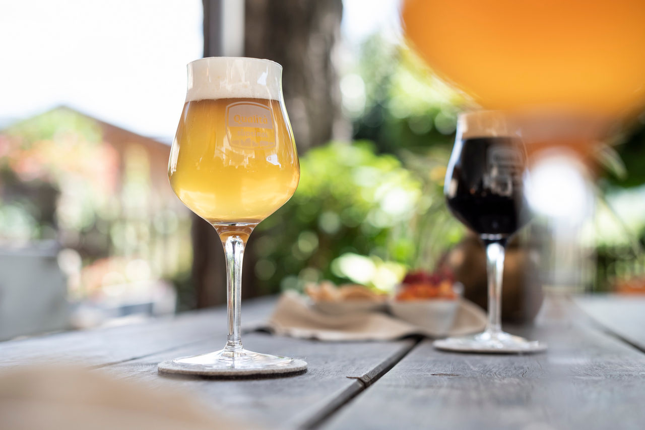 Drei Gläser Südtiroler Bier die auf einem Holztisch stehen