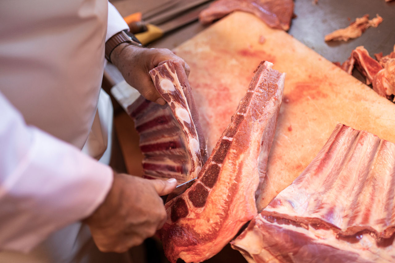 Metzger Alexander Holzner beim Zerteilen von Frischfleisch.