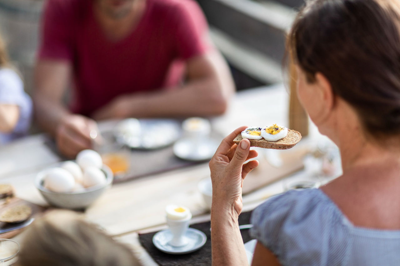 A woman eating bread and boiled eggs