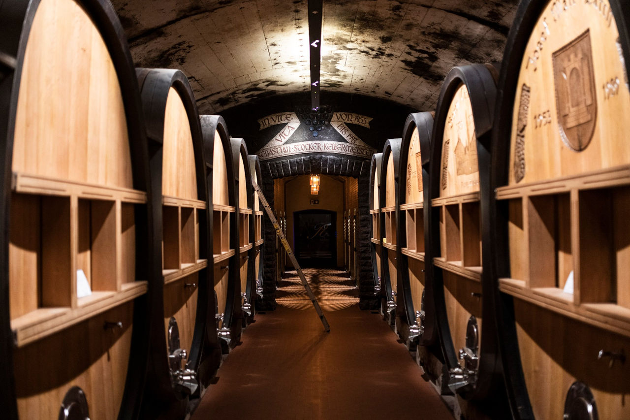 Mehrere aufgereite Weinfässer im Keller der Kellerei Terlan