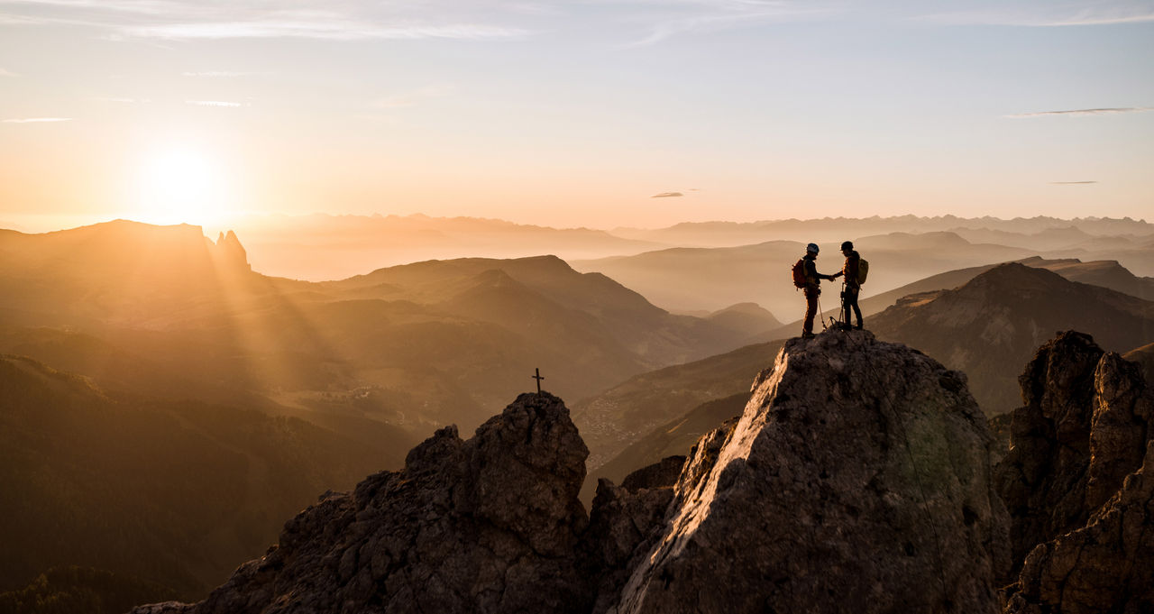 Zwei Kletterer genießen den Sonnenuntergang auf dem Gipfel der Cirspitze
