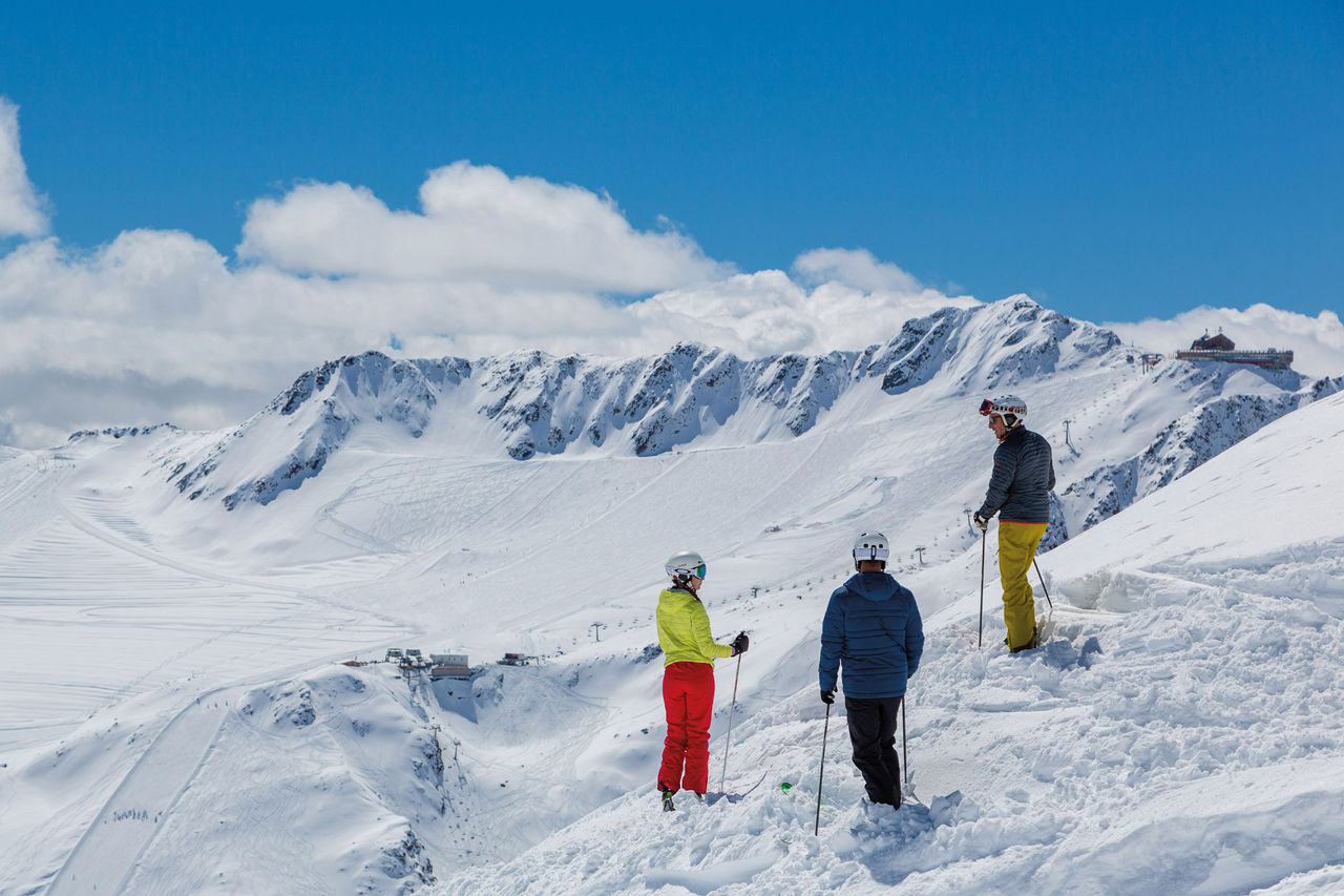 Drei Personen nutzen die Schneepiste im Schnalstal im Winter 