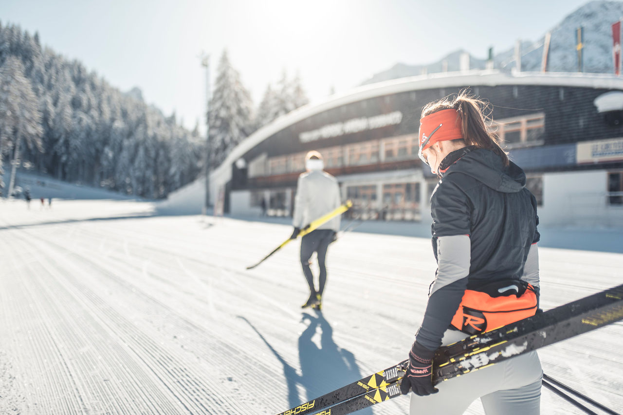 Eine Frau lächelt kurz vor der Abfahrt im Skigebiet Dolomiti Superski. 