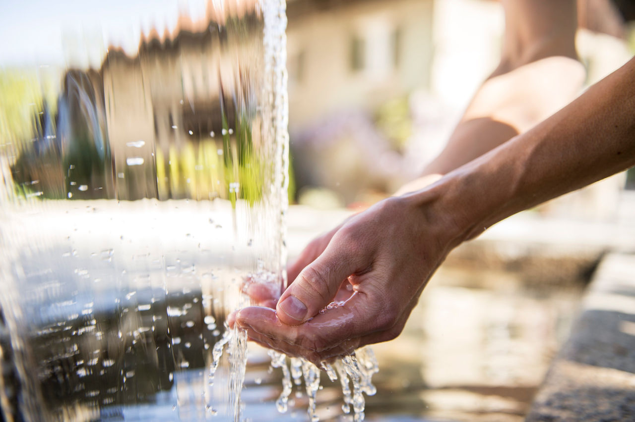 Eine Person hält hre Hände unter fließendes Wasser