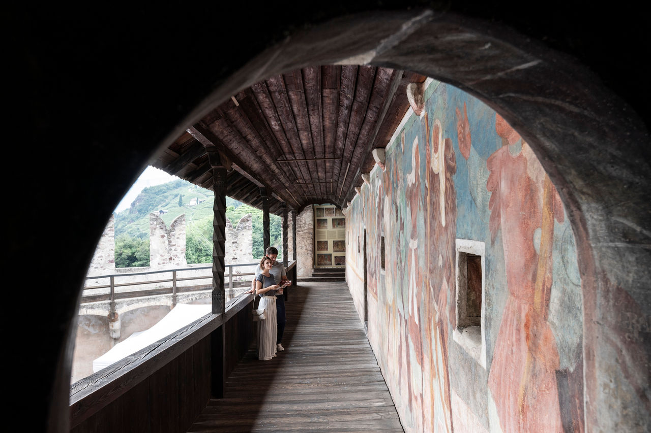 Zwei Besucher bestaunen das Fresko in der Bilderburg Runkelstein