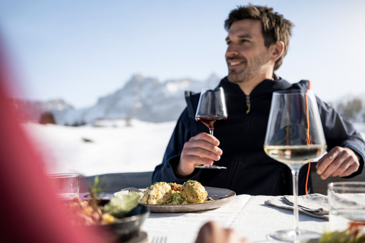 Zwei Personen genießen Südtiroler Speisen im freien im Winter