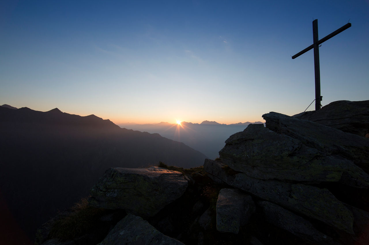 Blick auf das Gipfelkreuz im Naturpark Texelgruppe am Meraner Höhenweg | Alta Via di Merano bei Sonnenaufgang