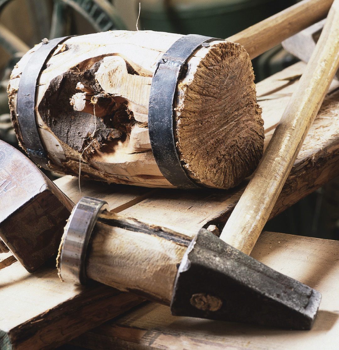 Verschiedene Werkzeuge aus Holz liegen auf einem Holzbalken