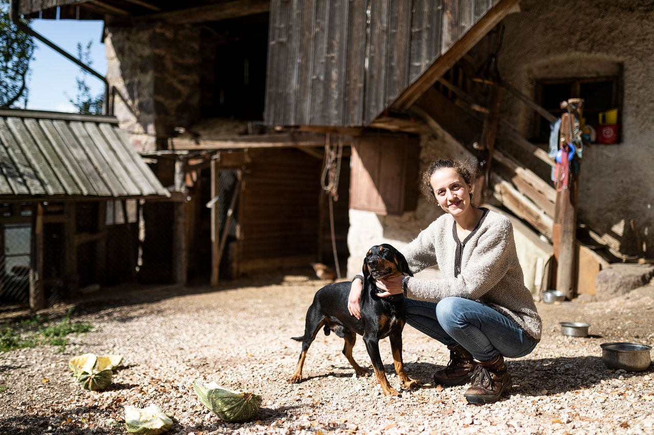 Anna Pfeifer steht mit ihrem Hund vor dem Haus