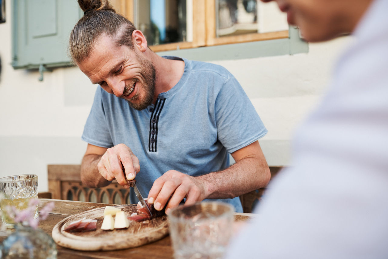 Eine Person schneidet ein Stück Speck