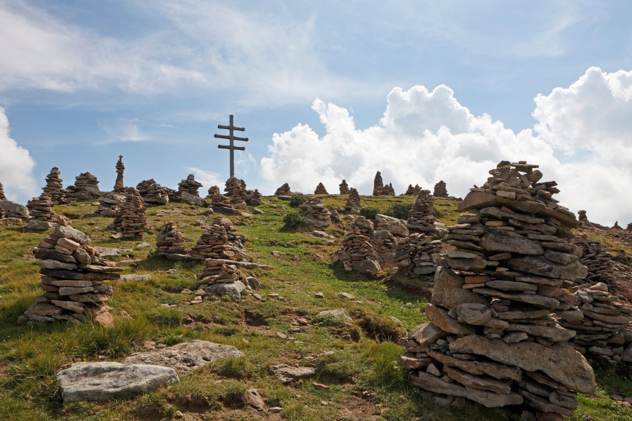 Bergkuppe mit Wetterkreuz und zu Skulpturen aufgeschichtete Steine