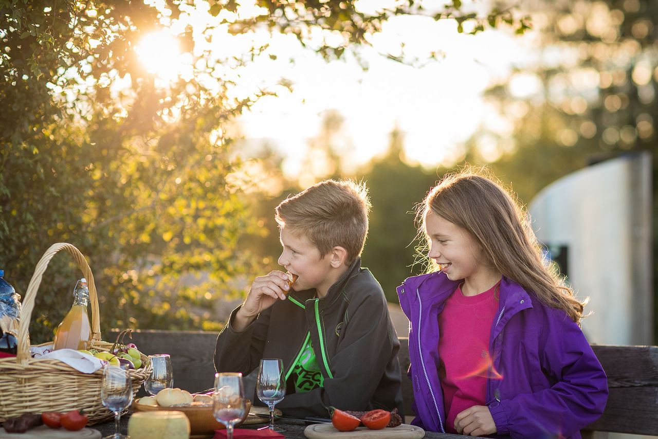 Ein Junge und ein Mädchen essen in der Sonne zünftig zu Abend.