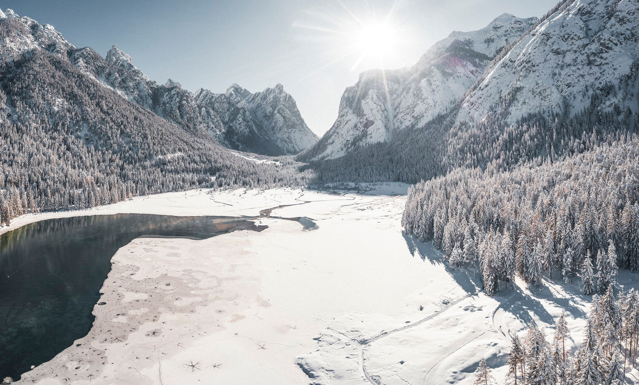 Der teilweise zugefrorene und schneebedeckte Toblacher See im Sonnenschein.