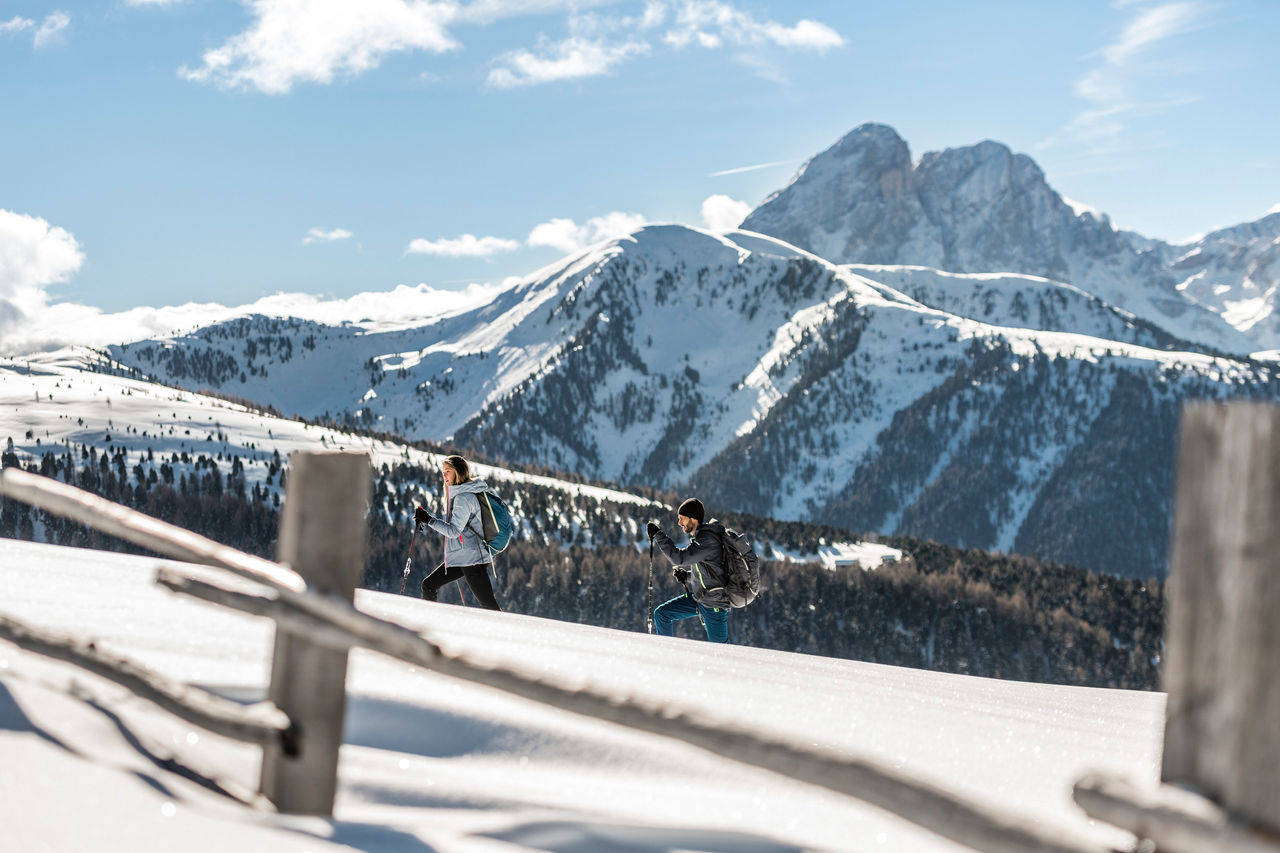 Eine Frau und ein Mann wandern durch den Schnee auf der Lüsner Alm.