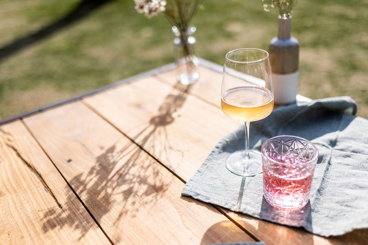 Auf einem Holztisch stehen zwei Glässer Apfel Cider