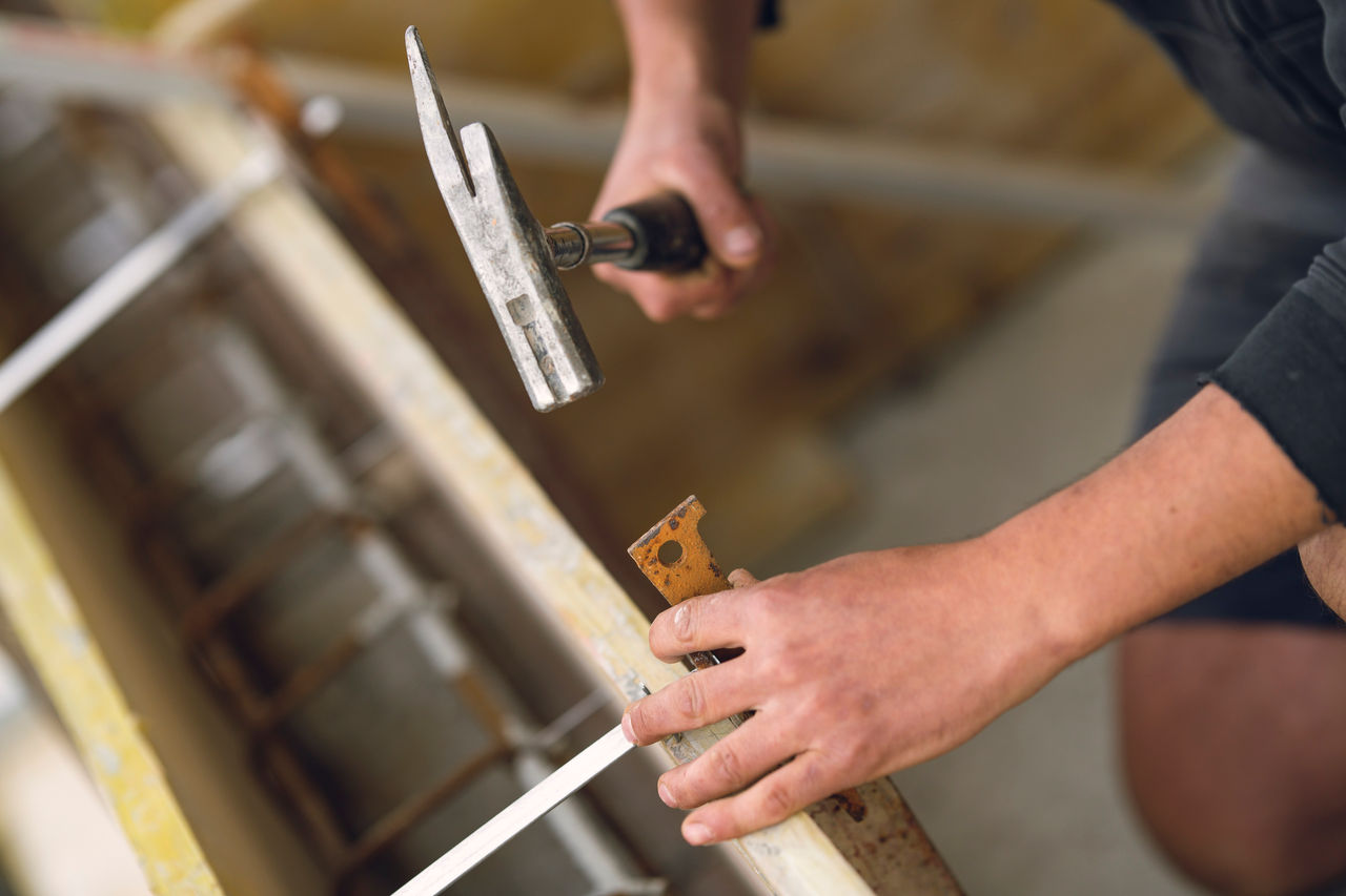 Handwerker arbeitet mit einem Hammer in der Hand